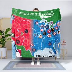 a man is standing in front of a towel with the map of the united states of baseball