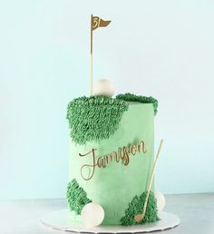 a green cake with a golf ball and tees on the top that says jameson