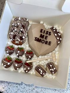 a heart shaped cake in a box with strawberries and marshmallows on it