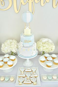 a table topped with cupcakes and cakes covered in frosting