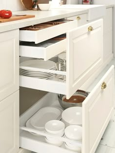 an open cabinet in a kitchen with plates and bowls