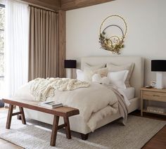 a large bed sitting in a bedroom next to a wooden table with two lamps on it