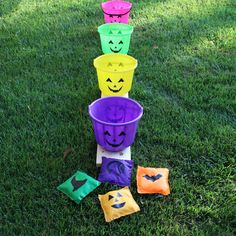 plastic cups with faces painted on them sitting in the grass