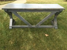 a wooden bench sitting on top of a lush green field