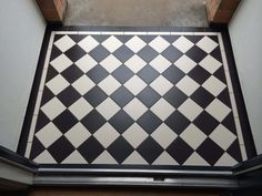 a black and white tiled floor in the corner of a building