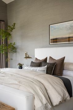 a white bed sitting in a bedroom next to a window