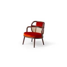 a red chair sitting on top of a white floor next to a wooden frame and armrest