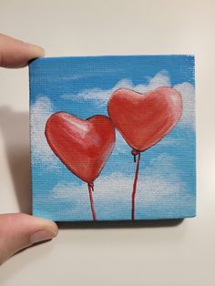 a painting of two red hearts on a blue sky