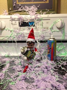 an elf is in the middle of some shredded up purple stuff and has his head on top of a can