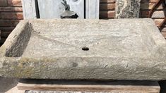 an old stone sink sitting in front of a door