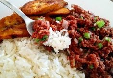 a white plate topped with rice and meat