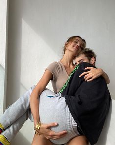 a man and woman hugging each other while sitting on a couch