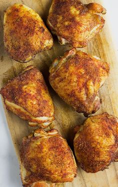 four pieces of chicken on a cutting board