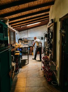 a man standing in a kitchen next to a stove