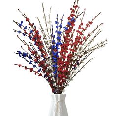 a white vase filled with red, white and blue flowers