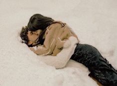 a woman is laying in the snow on her stomach