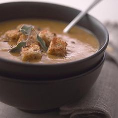 a black bowl filled with soup on top of a table