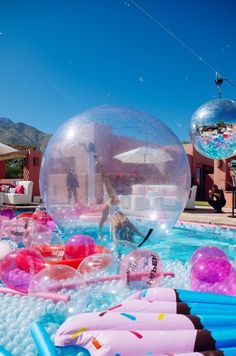 inflatable toys are floating on top of the water and around an inflatable ball