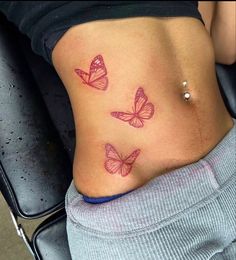 a woman's stomach with three pink butterflies on it