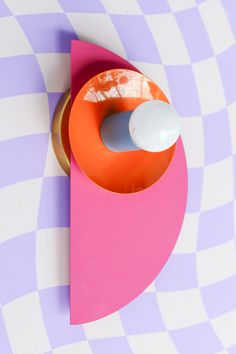 an orange and pink object sitting on top of a checkered table