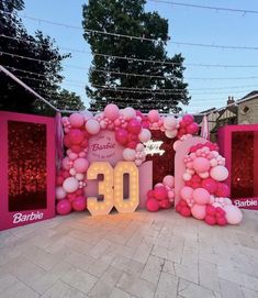 the entrance to barbie's 30th birthday party is decorated with balloons and streamers