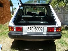 the back end of a white car with its trunk open