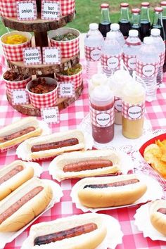 there are many hotdogs on the table with condiments and ketchup