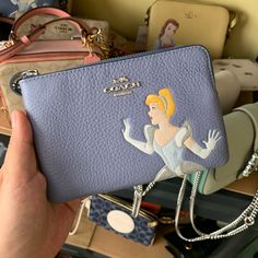 Disney X Coach Corner Zip Wristlet With Cinderella Product Details Refined Pebble Leather Two Credit Card Slots Zip-Top Closure, Fabric Lining Wrist Strap Attached 6 1/4" (L) X 4" (H) X 1/2" (W) Fits An Iphone Or Android Disney X Coach Disney Style No. C3361 Disney Coach Wallet, Coach X Disney, Disney Coach, Disney Shopping, Disney Stuff, Coach Disney, Disney Wallet, Tumblr Girly Aesthetic 2013, Disney Purse