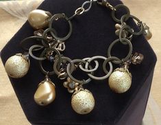 a close up of a bracelet on a display case with pearls and other jewelry items