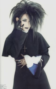 a man with black hair and makeup wearing a costume