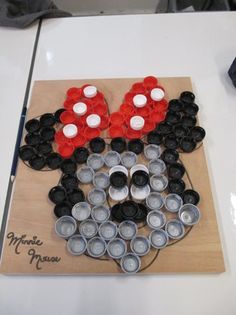 a mickey mouse made out of cupcakes on top of a wooden cutting board