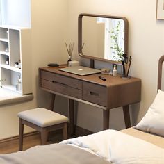 a bedroom with two beds and a desk with a mirror on it's side