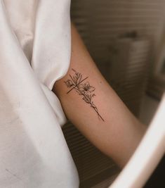 a woman's arm with a flower tattoo on the left side of her arm