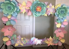 a decorated mirror frame with paper flowers on it