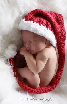 a newborn baby is wearing a santa hat