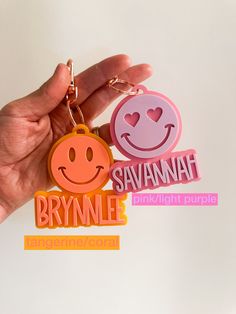 someone is holding two keychains with smiley faces on them and the words say, savannah