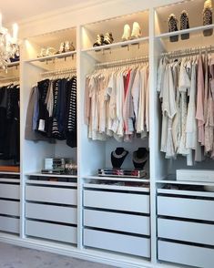 an organized closet with clothes and shoes on the shelves, chandelier hanging from the ceiling