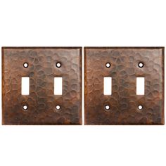 two metal switch plates with holes in them on a white background, one is brown and the other is black