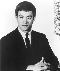 a man in a suit and tie sitting at a desk with his hand on the keyboard