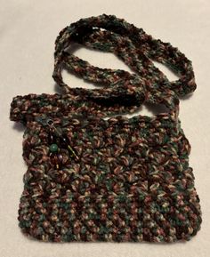 This crossbody bag is crocheted in the brown and green shades of the forest.  It closes with a zipper which is adorned with a charm of glass beads attached with a lobster clasp. The small bag is fun and has a variety of uses. The bag is approx. 8 inches long by 5.5 inches wide.  The bag drop is 23 inches Hand wash and dry on delicate for best results. Brown Crochet Bag For Gift, Crochet Brown Shoulder Bag For Gift, Crochet Brown Shoulder Bag Gift, Brown Crochet Shoulder Bag Gift, Brown Crochet Shoulder Bag As Gift, Brown Crochet Shoulder Bag For Gift, Crochet Shoulder Bag, Green Shades, Brown And Green