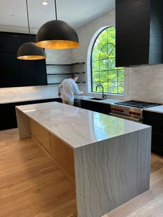 a man standing in a kitchen next to an island