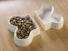 two white containers with food inside on a wooden table next to another container filled with coffee beans