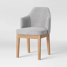 a grey chair sitting on top of a white floor next to a wooden frame and legs