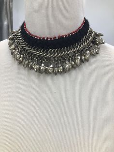 * This beautifully handcrafted silver color shade necklace is the epitome of tradition. The metallic weaving technique and dangling beads at the bottom are flaunting all the tribal vibes. The thread work at the top has complimented the whole theme of the necklace. You can pair this elegant piece of craft with any traditional or trendy outfit. Note: The product is handmade, slight change might occur in the actual product. Black Bohemian Necklace For Celebration, Handmade Silver Dangle Choker, Silver Bohemian Beaded Choker, Adjustable Silver Beaded Drop Necklace, Silver Beaded Necklaces For Celebration, Handmade Traditional Silver Beaded Necklaces, Handmade Silver Traditional Beaded Necklaces, Traditional Handmade Silver Beaded Necklaces, Handmade Silver Beaded Traditional Necklace