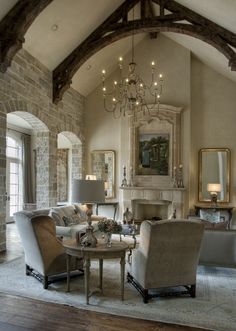 a living room filled with lots of furniture and a chandelier hanging from the ceiling