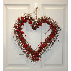 a heart shaped wreath hanging on the front door