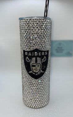 the oakland football team crystal tumbler is adorned with swarongs and beads