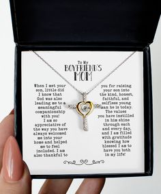 a person holding a necklace with a cross on it in a box that says, to my boyfriend's mom