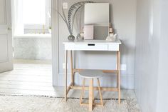 a white desk with a mirror and stool