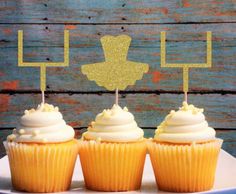 three cupcakes sitting on top of a white plate with gold glittered decorations